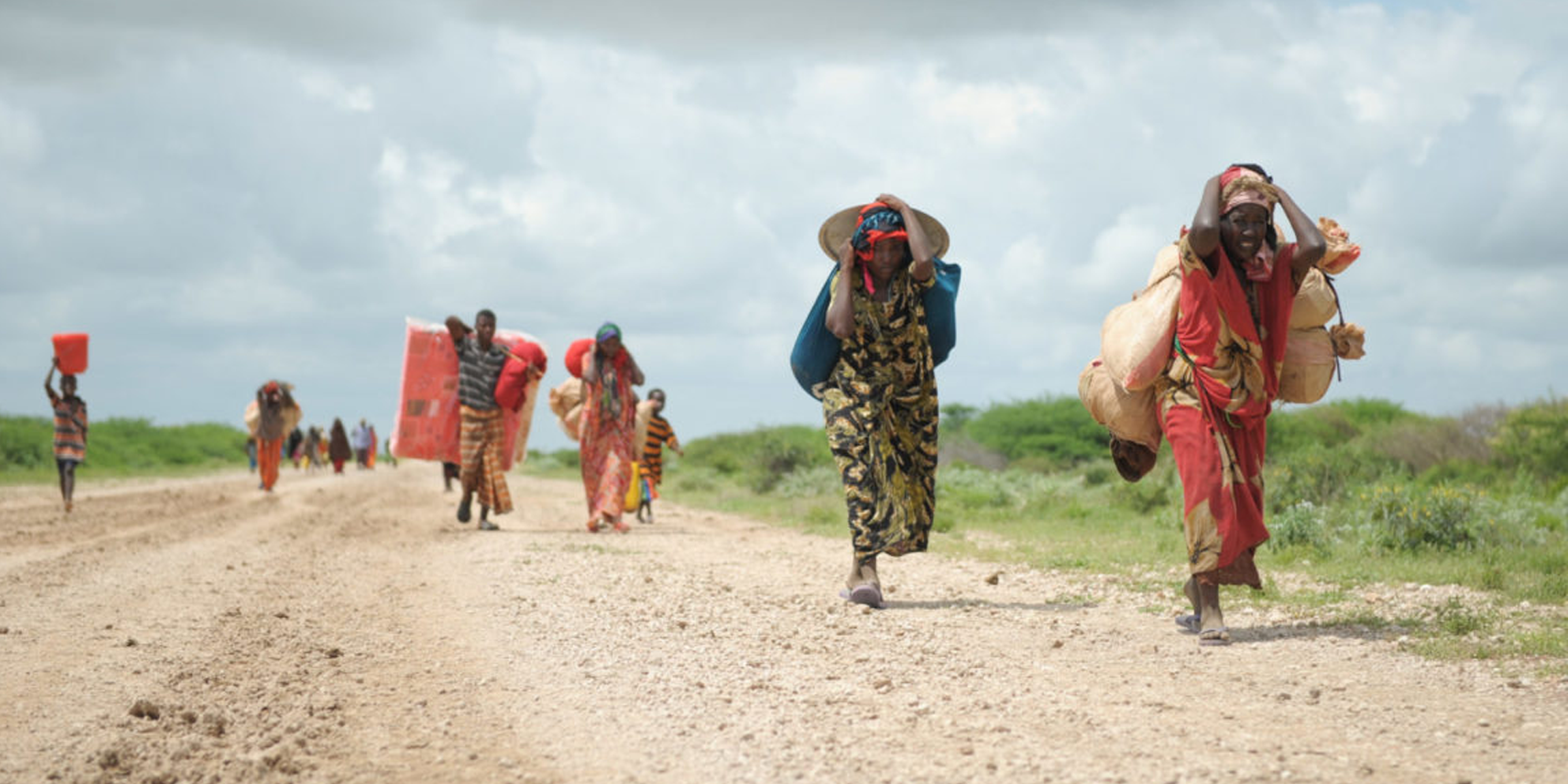 Människor på flykt undan klimatkatastrof och krig i Somalia gående på en väg i det uttorkade landskapet